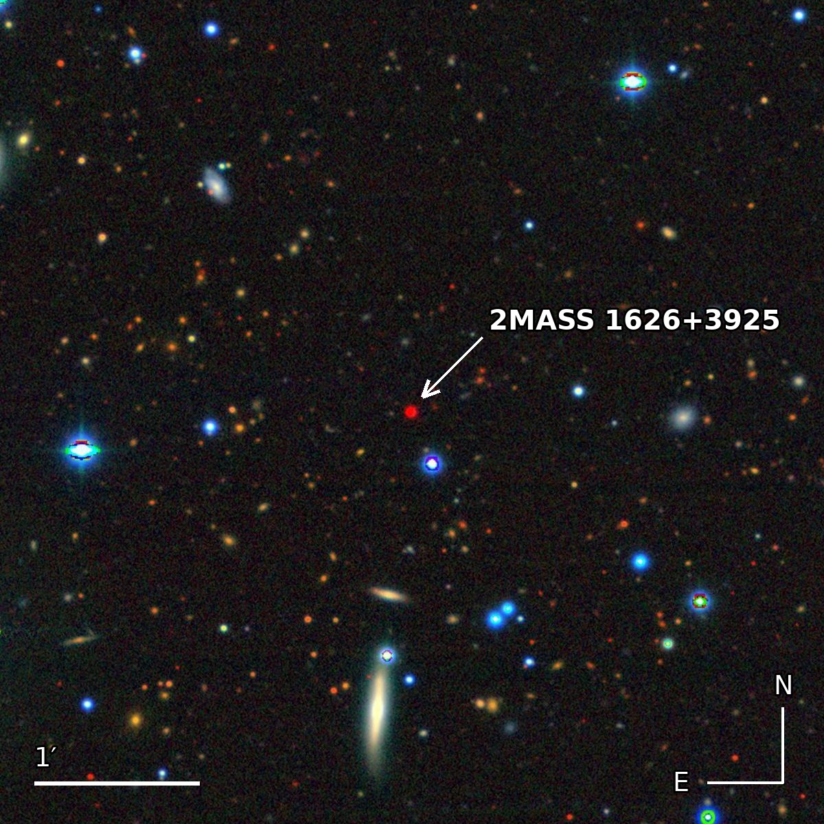 Un campo di cielo largo 5 primi d'arco, ricco di galassie lontane, con al centro 2MASS 1626+3925, indicata da una freccia.